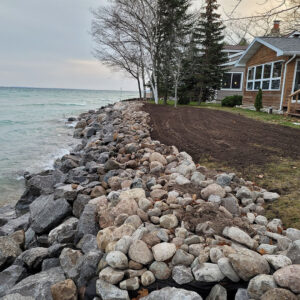 Waterfront property protected with rip rap boulders and freshly prepped yard ready for grass seed