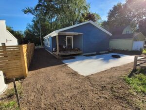 Newley constructed home on small lot with freshly excavated yard and concrete patio